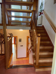 schodiště v mezipatře s možností jít dolů do obývacího pokoje a nahoru k pokojům